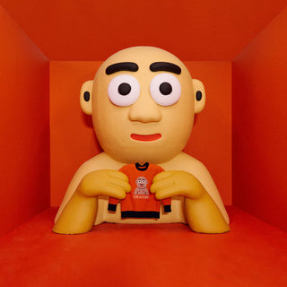 A stylized bald person holding a red sweater in a red room